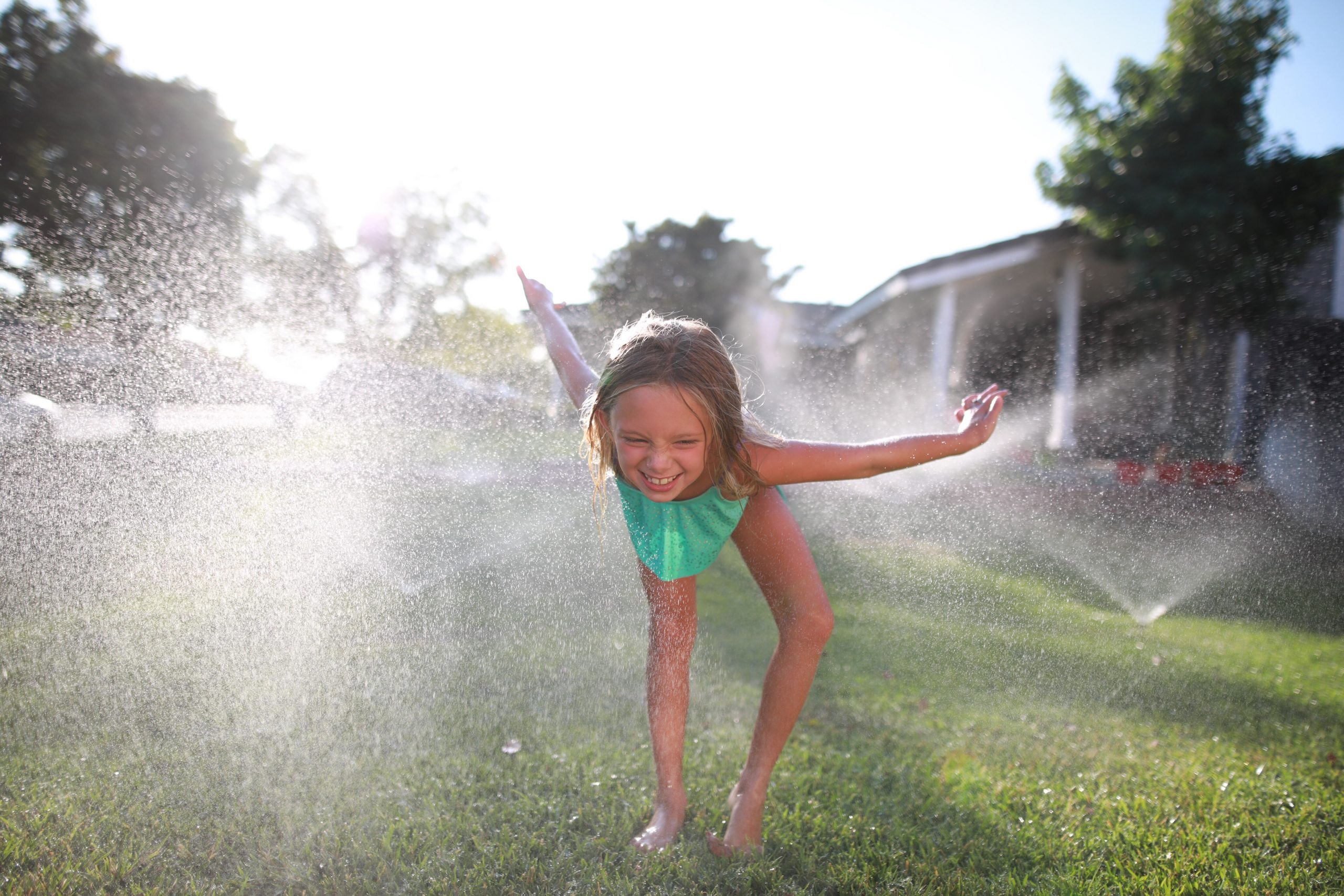 Young girl playing in sprinklers Perth Plumbing and Gasfitting